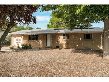 Charming brick home featuring a well-maintained front yard with mature trees and covered entry at 2520 Dover Ct, Lakewood, CO 80215