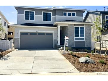 Two-story home with grey siding, stone accents, concrete driveway, and attached two-car garage at 455 S Salida St, Aurora, CO 80017