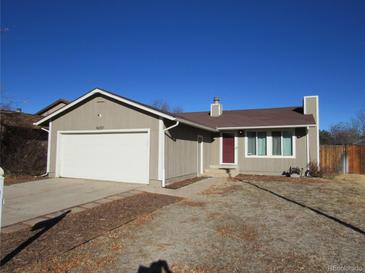 Tan one-story house with attached garage and red front door at 16757 E Mansfield Cir, Aurora, CO 80013