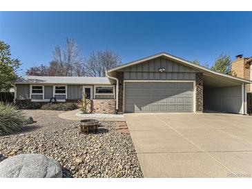 Charming single-story home featuring a well-manicured yard and attached two-car garage at 6953 W Roxbury Pl, Littleton, CO 80128
