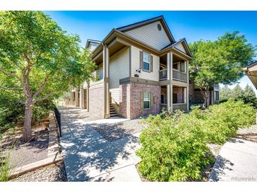 Two-story townhome with brick and siding exterior, walkway, and landscaping at 23376 E 5Th Pl # 101, Aurora, CO 80018