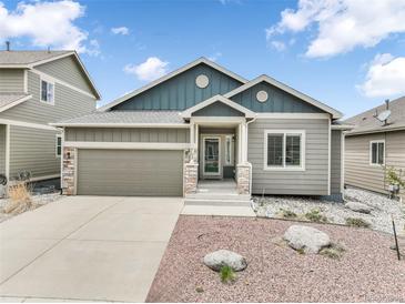 Charming single-Gathering home with a well-manicured lawn, concrete driveway, and attached two-car garage at 762 Tailings Dr, Monument, CO 80132
