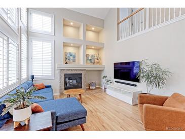 Bright living room with vaulted ceilings, fireplace, and hardwood floors at 360 Peregrine Cir, Broomfield, CO 80020