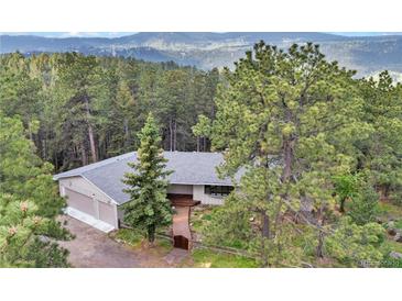 Secluded home exterior nestled in the woods with mountain views at 900 Ballantine Rd, Golden, CO 80401