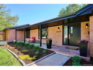 Inviting front entrance with a well-manicured garden, brick facade, and a cozy seating area on the covered porch at 3666 S Jersey St, Denver, CO 80237