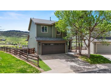 Charming two-story home with a spacious two-car garage, fenced yard, and beautiful landscaping at 9721 Marmot Ridge Cir, Littleton, CO 80125