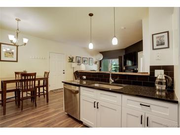 Bright kitchen featuring a black granite countertop, stainless steel appliances and a dining area at 2430 W 82Nd Pl # 2F, Westminster, CO 80031