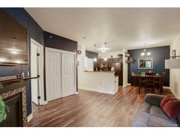 Bright, open living area featuring wood floors, a decorative fireplace, and seamless flow to the dining area at 2430 W 82Nd Pl # 2F, Westminster, CO 80031