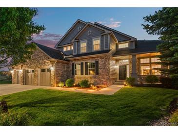 Charming two-story home features a stone facade, well-manicured lawn, and attached three car garage at 3041 Starling Ct, Castle Rock, CO 80109