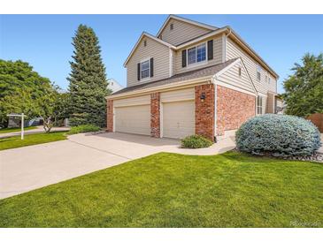 Two-story home with a well-manicured lawn and two-car garage, showcasing its inviting curb appeal at 2561 Cactus Bluff Pl, Highlands Ranch, CO 80129