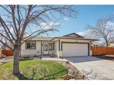 Charming single-story home boasts a well-manicured lawn, attached two-car garage, and welcoming front entrance at 2085 S Deframe St, Lakewood, CO 80228