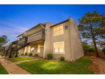 Two-story apartment building featuring balconies, green lawn, and beautiful landscaping at dusk at 7110 S Gaylord St # O7, Centennial, CO 80122