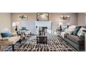 Inviting living room features a cozy fireplace and comfortable seating at 2925 S Ingalls Way, Denver, CO 80227