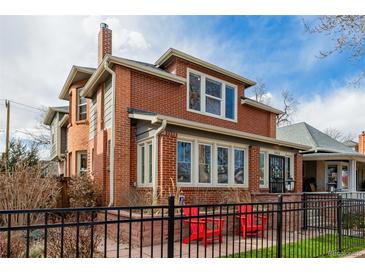 Charming brick home featuring a classic design with a welcoming front porch and a well-maintained front yard at 1053 S Washington St, Denver, CO 80209