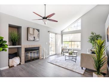 Bright living room with vaulted ceiling, fireplace, fan, and sliding doors to the outside at 13782 E Lehigh Ave # B, Aurora, CO 80014