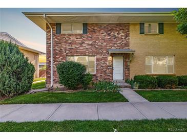 Charming brick townhome with a well-manicured front lawn and inviting entryway at 9042 E Lehigh Ave, Denver, CO 80237