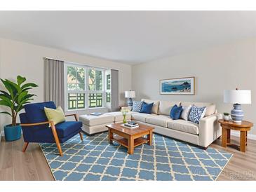 Bright living room with stylish blue accents and a large window overlooking the yard at 620 S Alton Way # 5B, Denver, CO 80247