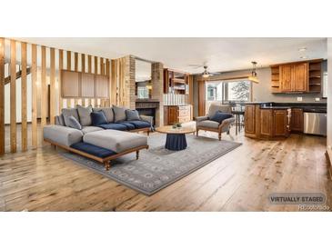 Inviting living room showcasing a cozy fireplace, hardwood floors, and stylish, comfortable seating at 11153 W 17Th Ave # 101, Lakewood, CO 80215