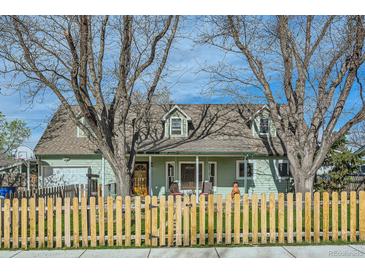 Charming home with a welcoming front porch and picket fence, framed by mature trees at 1065 6Th St, Berthoud, CO 80513