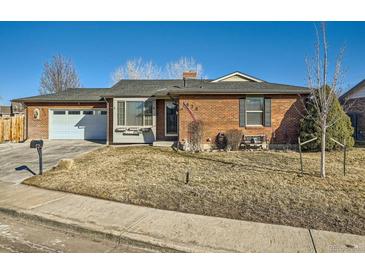 Charming red brick home with a well-maintained front yard and attached garage at 438 N 11Th Ave, Brighton, CO 80601