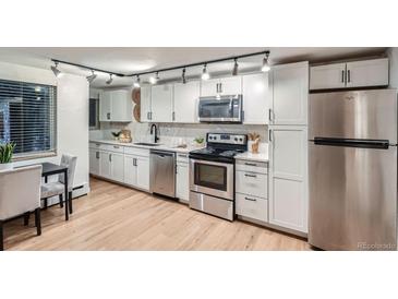 Updated kitchen with white cabinets, stainless steel appliances, and quartz countertops at 155 S Pennsylvania St # 101, Denver, CO 80209