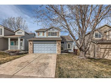 Charming two-story home featuring a two-car garage, light blue siding, and a well-maintained front yard with mature trees at 3532 Morning Glory Dr, Castle Rock, CO 80109