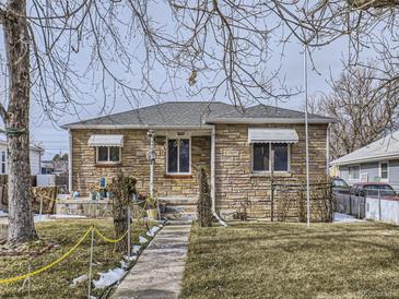 Ranch style home with stone exterior, walkway, and mature trees at 1333 Hanover St, Aurora, CO 80010