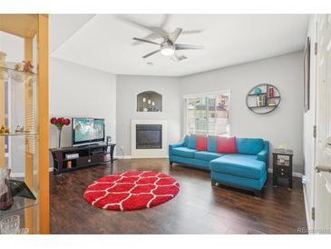Bright living room with hardwood floors, fireplace, and a comfortable blue sectional sofa at 8653 E Dry Creek Rd # 1114, Englewood, CO 80112