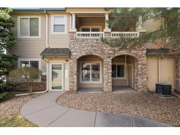 Charming condo featuring stone accents, a covered porch, and well-maintained landscaping at 8358 S Independence # 107, Littleton, CO 80128