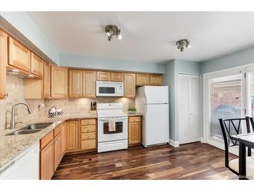 Bright kitchen featuring wood cabinets, granite countertops, and stainless steel appliances at 1201 Galapago St # 109, Denver, CO 80204