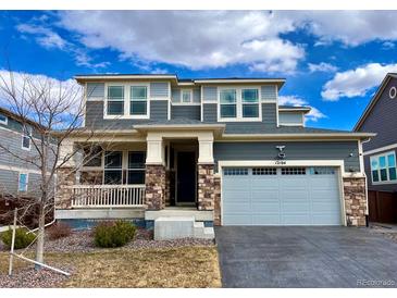 Beautiful two-story home with a well-manicured lawn, gray siding, and a two-car garage at 12164 Poplar St, Thornton, CO 80602