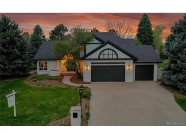 Charming home with a three-car garage, well manicured lawn, professional landscaping and an inviting walkway at 44 Spyglass Dr, Littleton, CO 80123