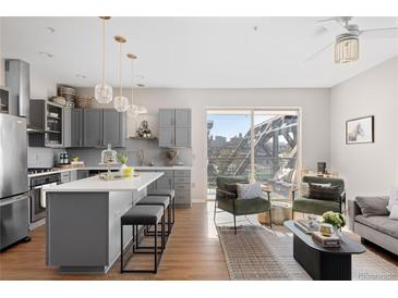 Modern kitchen with gray cabinets, island, and stainless steel appliances at 1440 Little Raven St # 204, Denver, CO 80202