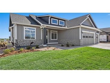 Charming gray single-Gathering home features a well-manicured lawn and stone accents at 1369 Burt Ave, Berthoud, CO 80513