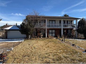 Charming two-story home with brick and siding exterior and a lovely covered balcony, perfect for relaxing outdoors at 8722 S Balsam St, Littleton, CO 80128