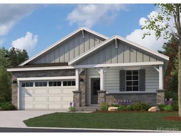 Charming single-story home with stone accents, gray siding, a two-car garage, and manicured front yard at 13806 Honey Hush Trl, Parker, CO 80134