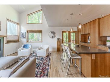Bright, open-concept living room flows into modern kitchen with bar seating and stainless appliances at 79 Huron Ct, Boulder, CO 80303