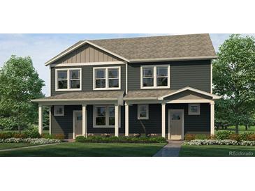Inviting townhome featuring a charming covered porch, manicured lawn, and elegant gray siding at 1356 S Boston Ct # A, Denver, CO 80247