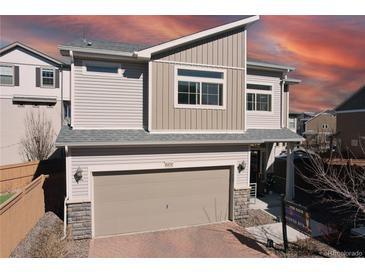 Beautiful two-story home with modern design, gray siding, and a two-car garage in a suburban neighborhood at 10232 Yampa Ct, Commerce City, CO 80022