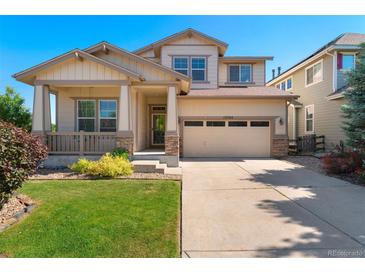 Charming two-story home with landscaped front yard, covered porch, and attached two-car garage at 13794 E Caley Dr, Englewood, CO 80111