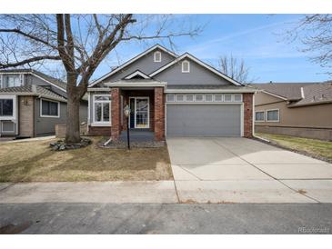 Charming home featuring a well-manicured lawn, mature trees, and a two-car garage at 9630 W La Salle Ave, Lakewood, CO 80227