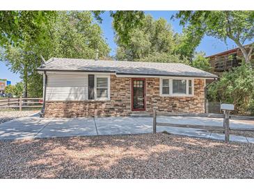Charming single-story home featuring stone accents, modern siding, and a well-manicured front yard at 1390 Estes St, Lakewood, CO 80215