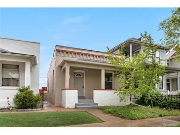 Charming single-story home featuring a cozy front porch with white pillars and a well-manicured lawn at 3045 Arapahoe St, Denver, CO 80205