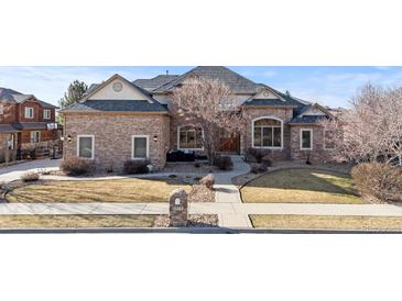 Beautiful stone home featuring a manicured front lawn and charming architectural details at 1313 Jade Ln, Longmont, CO 80504