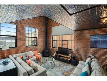 Cozy living room features exposed brick, a pressed tin ceiling, and a modern fireplace at 1515 N Ogden St # 7, Denver, CO 80218
