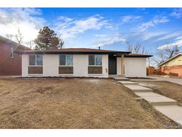 Charming single-story home with white painted brick, wood detail, and well-maintained landscaping at 8051 Clarkson Ct, Denver, CO 80229