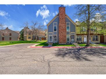 Inviting townhome featuring a classic brick chimney and a well-maintained front yard at 1662 S Blackhawk Way # A, Aurora, CO 80012