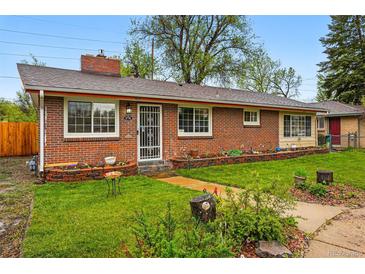 Charming single-story brick home featuring a well-manicured lawn and landscaped garden beds, creating a welcoming curb appeal at 8736 W 46Th Ave, Wheat Ridge, CO 80033