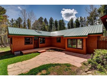 Charming exterior of home with wood siding, a green metal roof, and a stone pathway at 9123 Booker Ln, Conifer, CO 80433