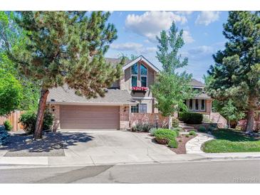 Charming two-story home with mature trees, brick accents, and a two-car garage at 5373 E Links Cir, Centennial, CO 80122